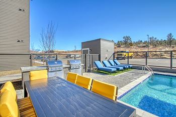 the deck has a pool and a table with chairs and a grill at 2051 Apartments, Prescott, 86301